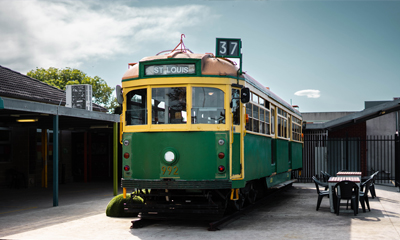 Green W Class tram standing in the playground of St Louis de Montfort school in Aspendale
