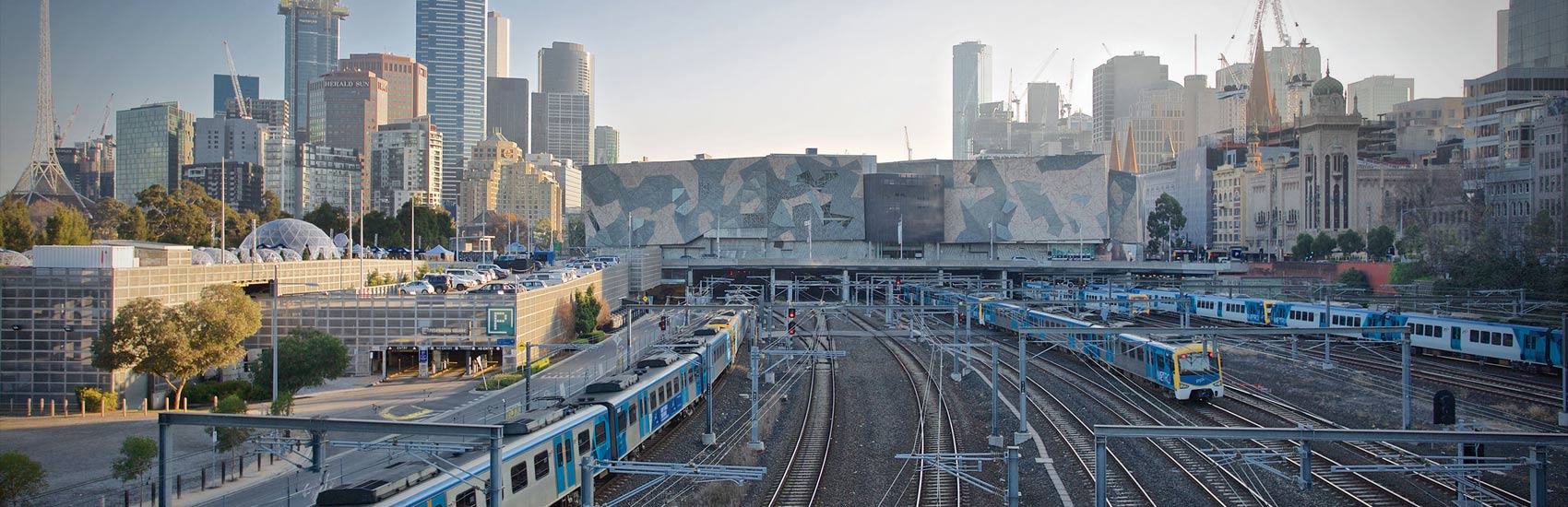 Flinders Station train tracks with Melbourne city skyline and buildings including Fed Square