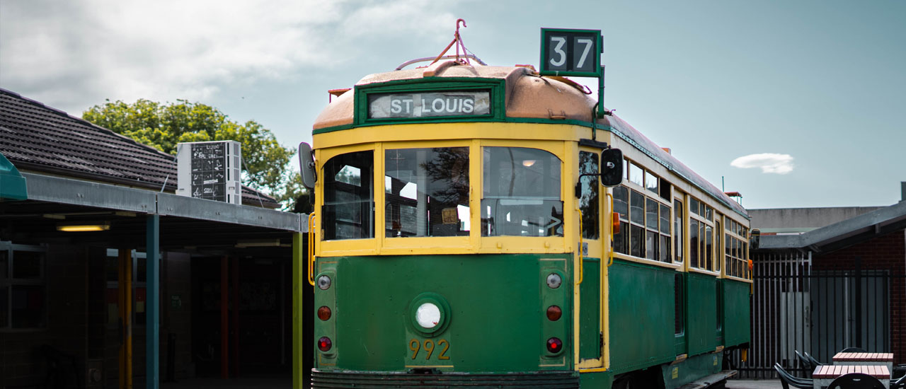 Green W Class tram standing in the playground of St Louis de Montfort Primary School in Aspendale