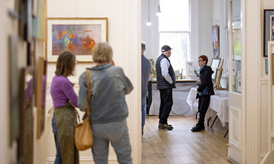 A group of people standing in an art gallery space