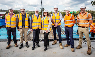 Minister for Public Transport Ben Carroll and Member for Monbulk Daniela De Martino stand at Belgrave Station with some other workers.